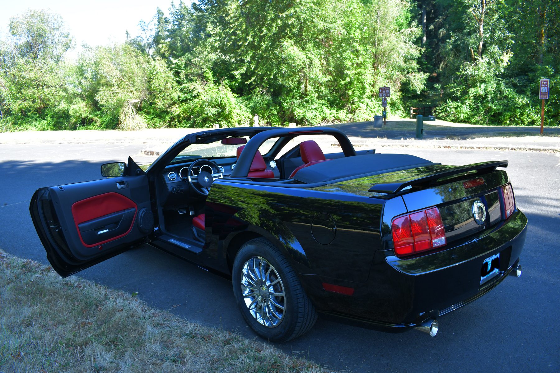 Rear three-quarter, door open, roll bar and red interior